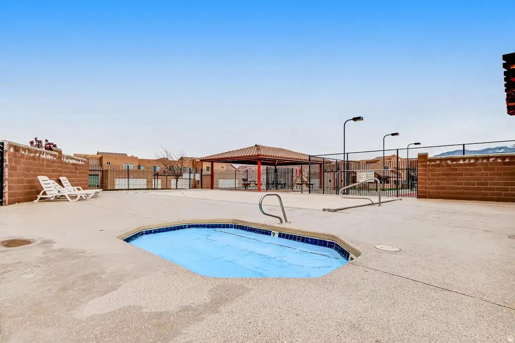 In-ground spa with a protective cover, surrounded by a concrete pool deck