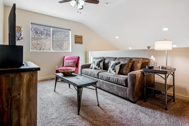 Sloped ceiling design, recessed lighting, and a ceiling fan