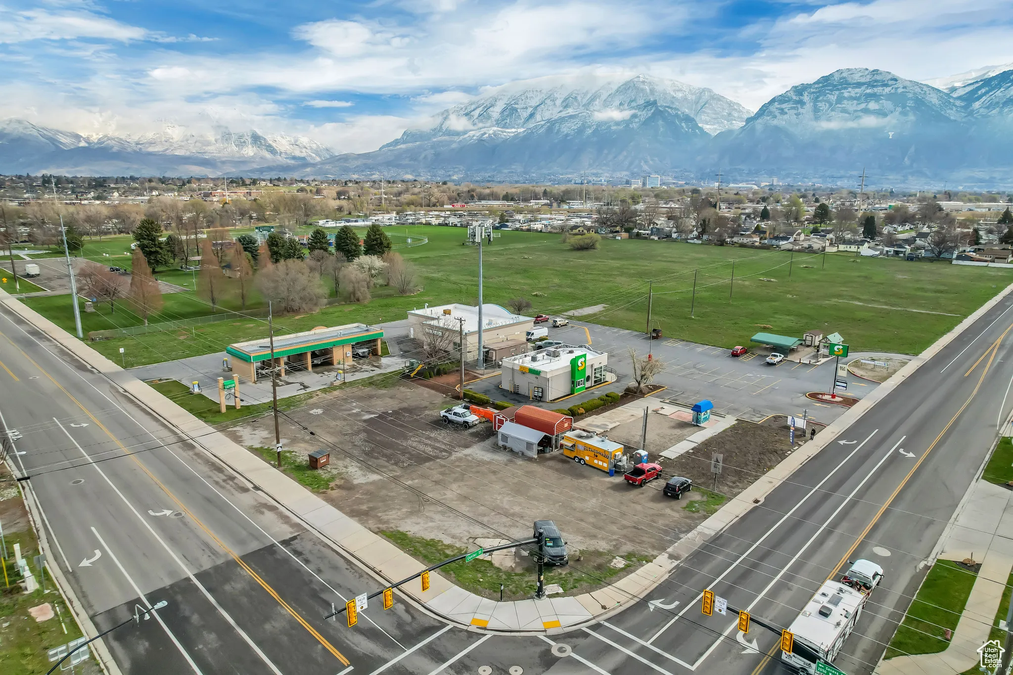 Prominent mountain backdrop, corner lot location, paved roadways, existing commercial structures, expansive open land parcel