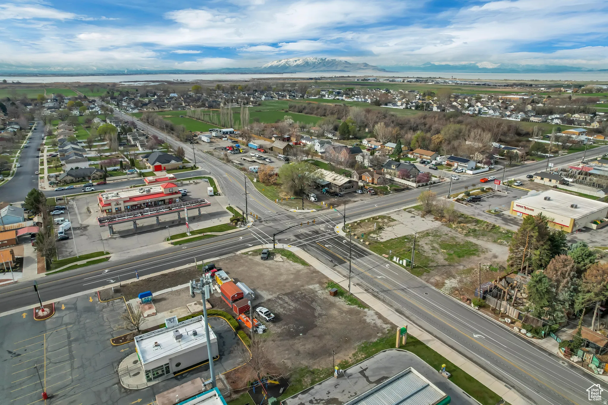 Expansive aerial perspective showcasing a commercial intersection, multiple commercial buildings, and surrounding residential areas