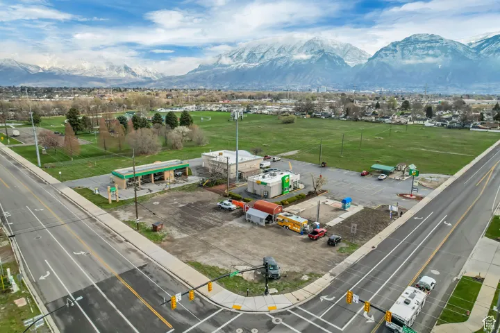 Prominent mountain backdrop, corner lot location, paved roadways, existing commercial structures, expansive open land parcel
