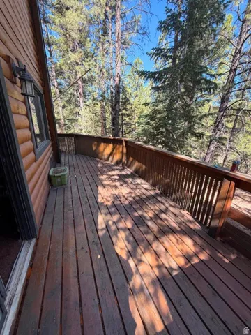 Expansive wood deck with wood railings, featuring a log cabin style exterior
