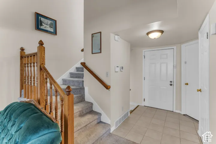 Foyer with tiled flooring, paneled entry door, and a flush mount ceiling light