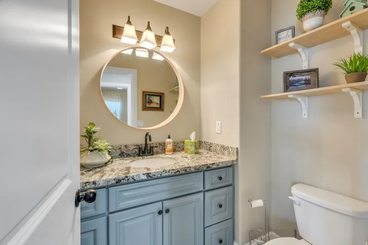 Vanity with a granite countertop, undermount sink, and black faucet