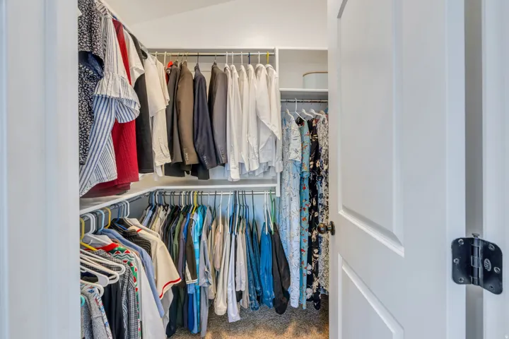 Custom built-in closet system with multiple hanging rods and shelving