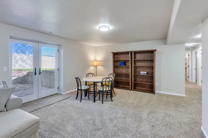 Light-colored carpeting throughout, white interior walls, and wooden bookshelves