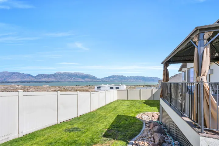 Expansive lawn with a white privacy fence and rock landscaping