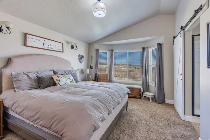 Vaulted ceilings enhance the room's height, complemented by a bay window.