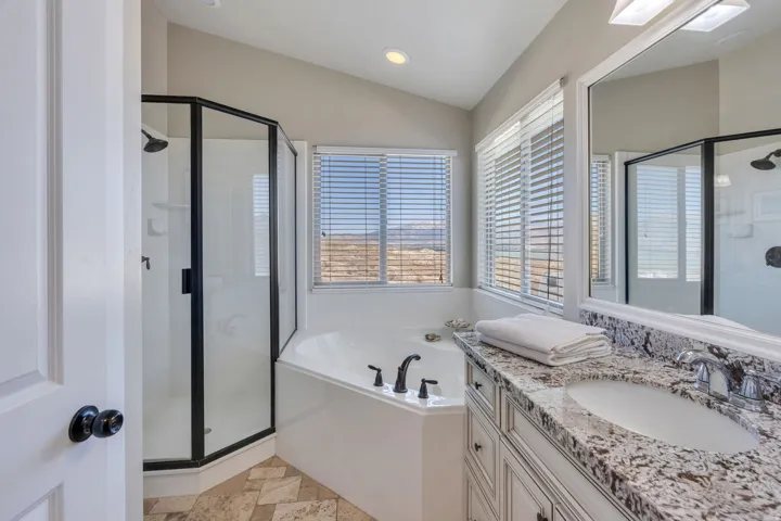 White vanity with granite countertop, integrated sink, and chrome faucet