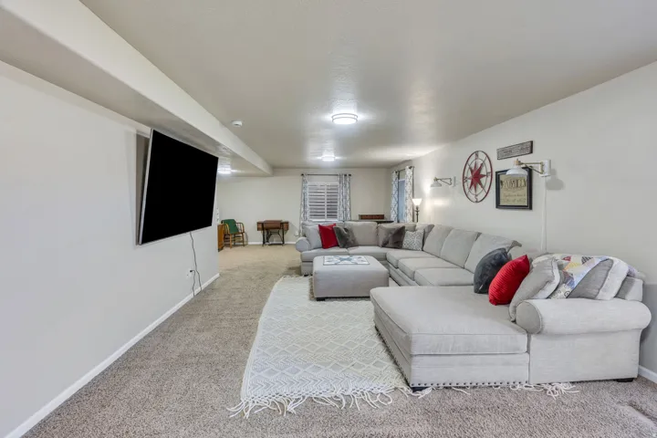 Recessed lighting, wall-mounted television, and carpeted flooring