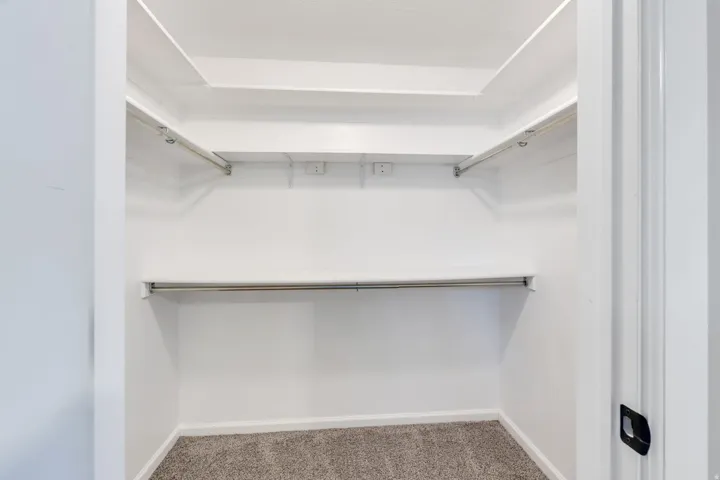White-painted walls and built-in shelving with hanging rods