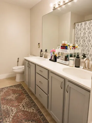 Dual vanity with light gray cabinetry, brushed nickel hardware, and a white countertop