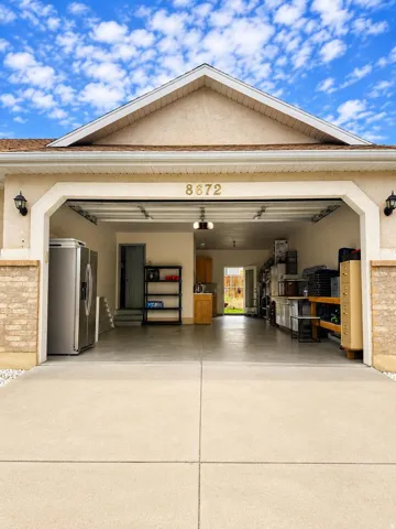 Concrete driveway leading to a two-car garage with overhead doors