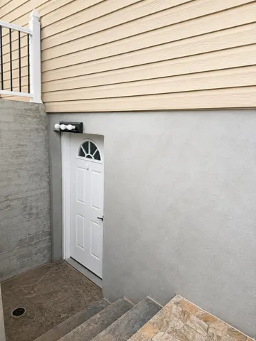 Cream-colored vinyl siding over a textured gray foundation