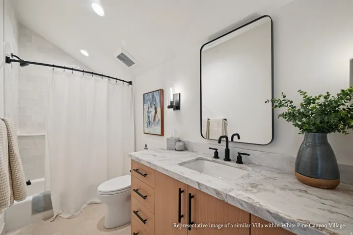 Vanity with a rectangular undermount sink, matte black faucet, and a stone countertop