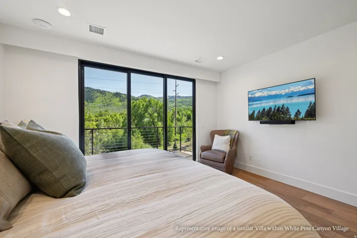 Full-height glass panel doors, recessed lighting, wood-finish flooring, and a wall-mounted television