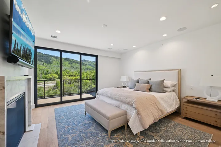 Hardwood-style flooring, a built-in fireplace with a stone-look surround, recessed lighting, and a full-width sliding glass door to a balcony with metal railings