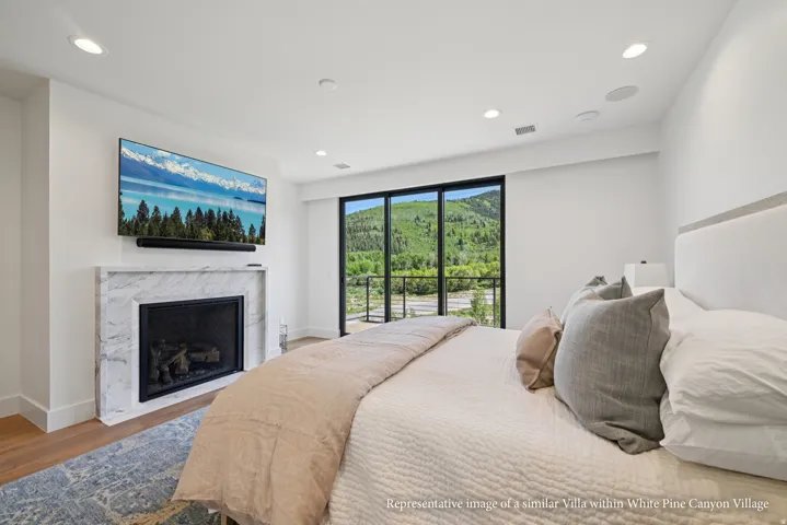 Marble-clad fireplace, floor-to-ceiling glass door, recessed lighting, wood-finish flooring, and built-in speakers