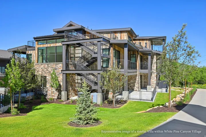 Multi-level exterior featuring stone and wood-finish siding, multiple balconies with glass railings, and an external metal staircase