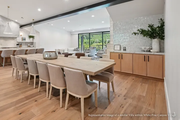 Wood-finish flooring throughout, with a built-in buffet featuring light wood cabinetry, a light countertop, and a tiled backsplash