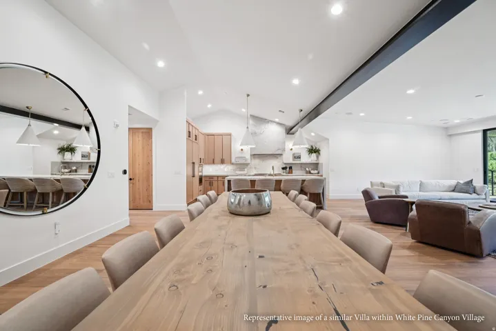Open-concept living space with wood-finish flooring, vaulted ceilings, and recessed lighting