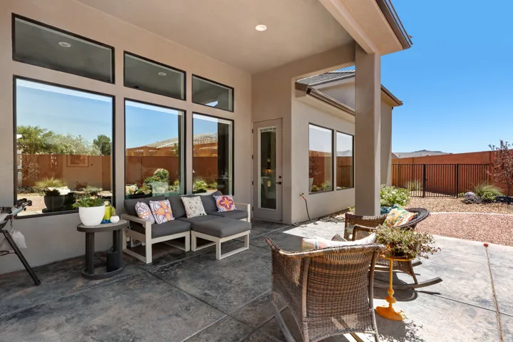 Covered patio with stamped concrete flooring, multiple large windows, recessed lighting, and a glass-paneled exterior door
