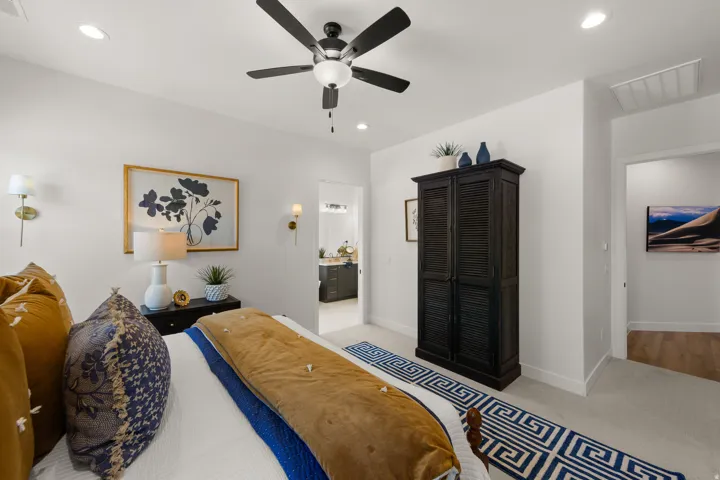 Recessed lighting, ceiling fan, wall sconces, and neutral carpeting