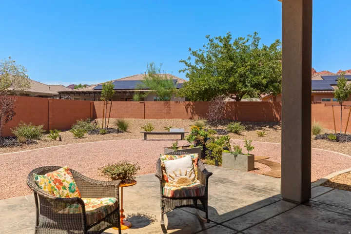 Patio with stamped concrete flooring, gravel landscaping, and a privacy wall