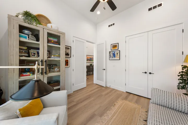 Vaulted ceiling, ceiling fan, wood-finish flooring, built-in shelving, paneled doors with black hardware