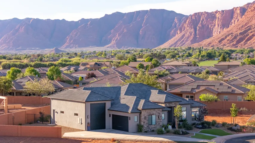 Stucco and stone exterior with a two-car garage, an additional single-car garage, and a concrete driveway