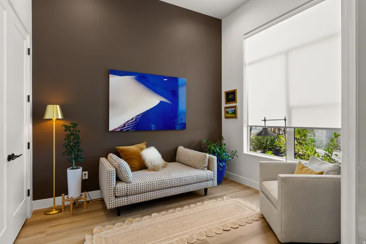 Wood-finish flooring with high ceilings, recessed lighting, and large windows with privacy shades