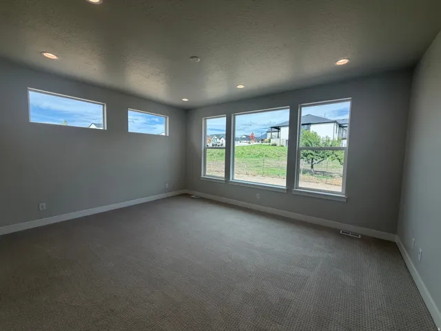 Recessed lighting, wall-to-wall carpeting, multiple large windows, and neutral wall paint