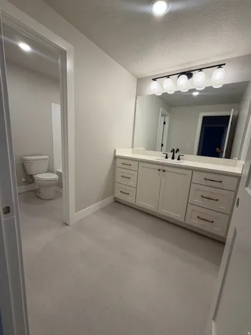 White vanity with ample storage, integrated sink, and black fixtures