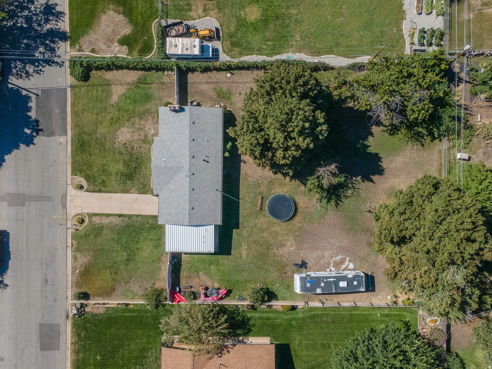 Expansive lot featuring mature trees, a long driveway, and a large grassy area
