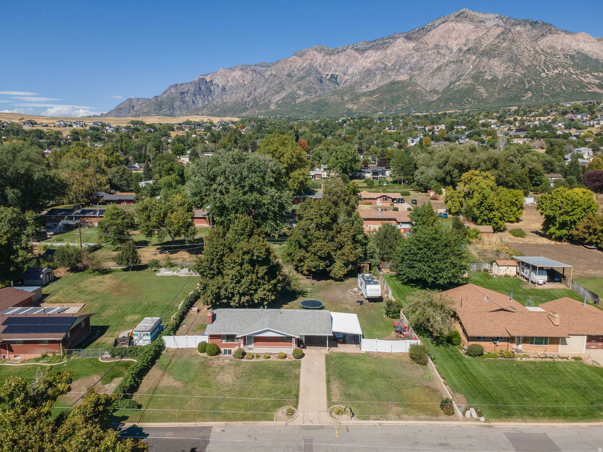 Expansive lot with a brick-clad residence featuring a covered entry and a long driveway