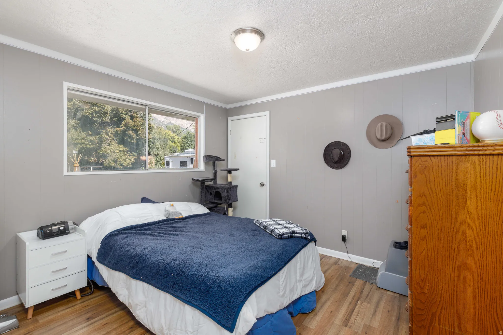 Wood-finish flooring with a white trim, a sliding window, and a built-in light fixture