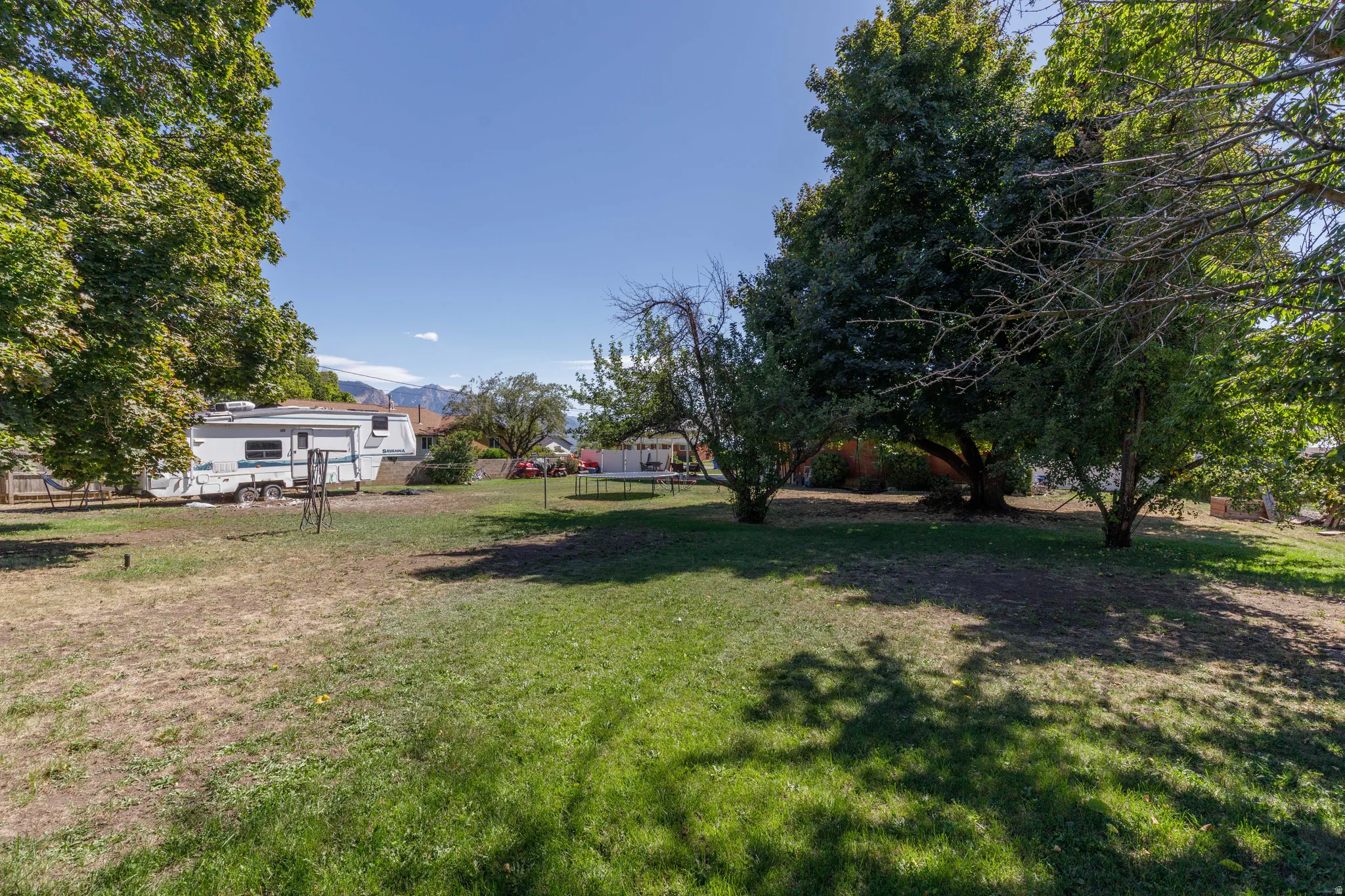 Expansive outdoor area featuring mature trees and a substantial grassy area