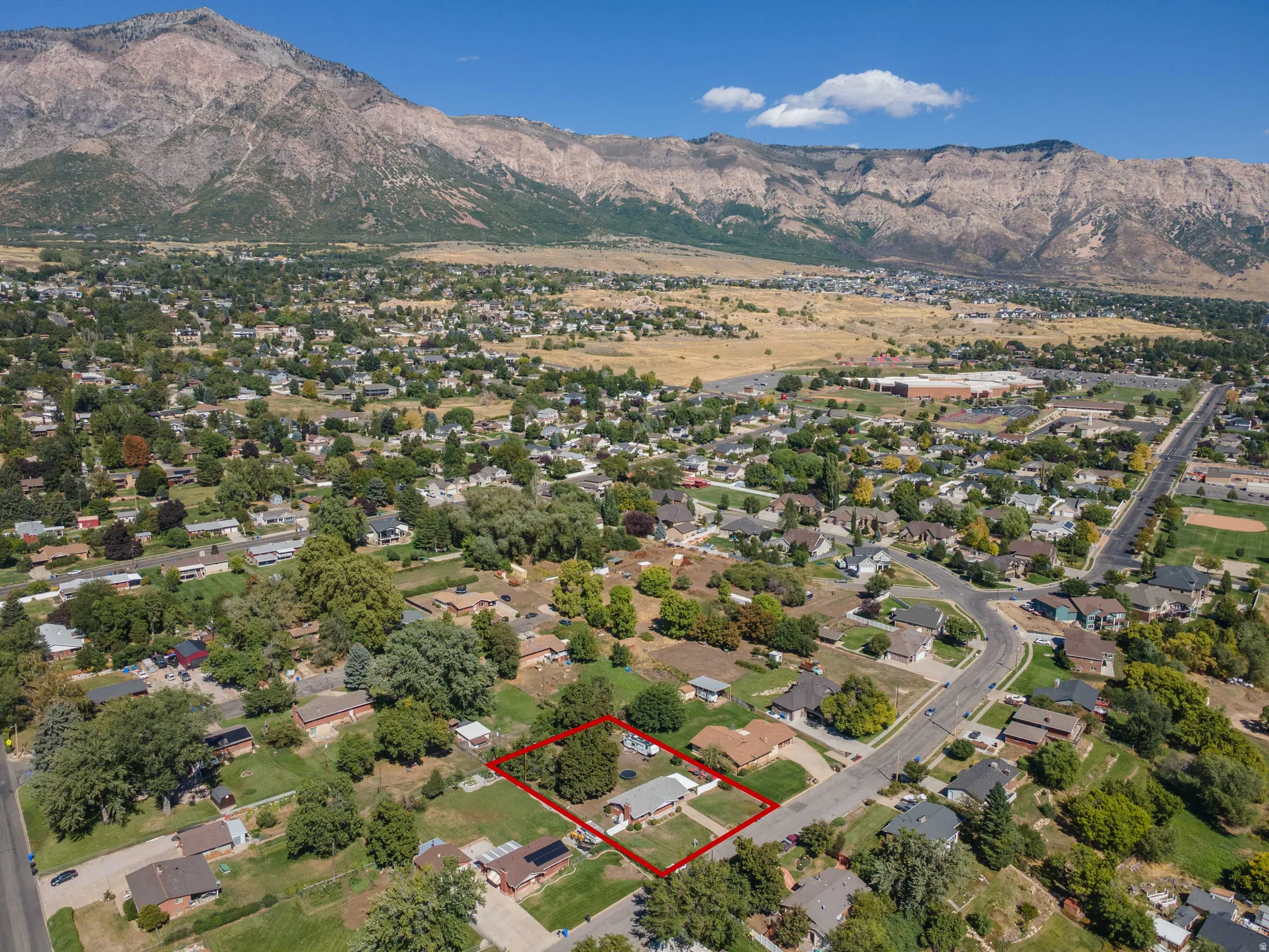 Residential property with surrounding mature trees and mountain backdrop