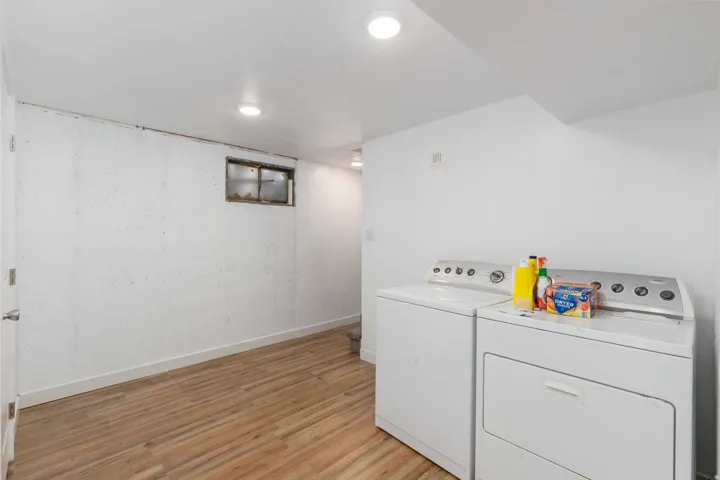 Laundry area featuring wood-finish flooring, recessed lighting, and a window