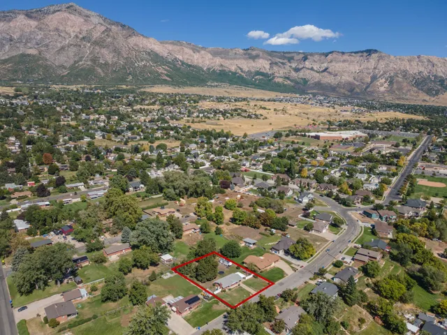 Residential property with surrounding mature trees and mountain backdrop