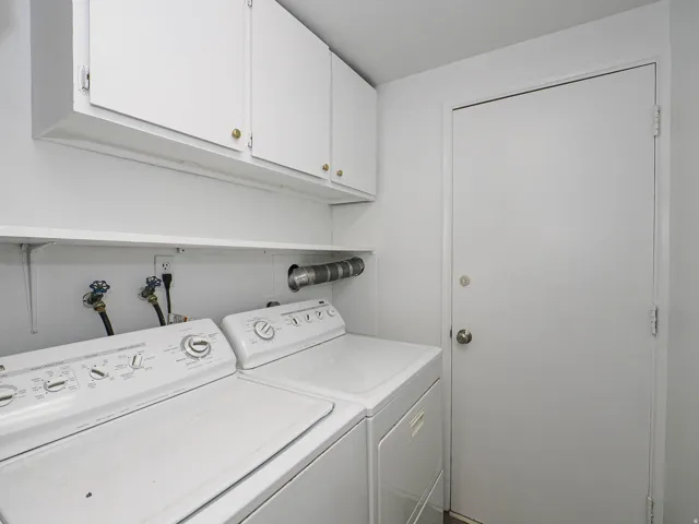 White cabinetry with brass hardware, open shelving, and a solid white door