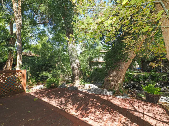 Wood-finish deck with lattice privacy fencing and mature trees