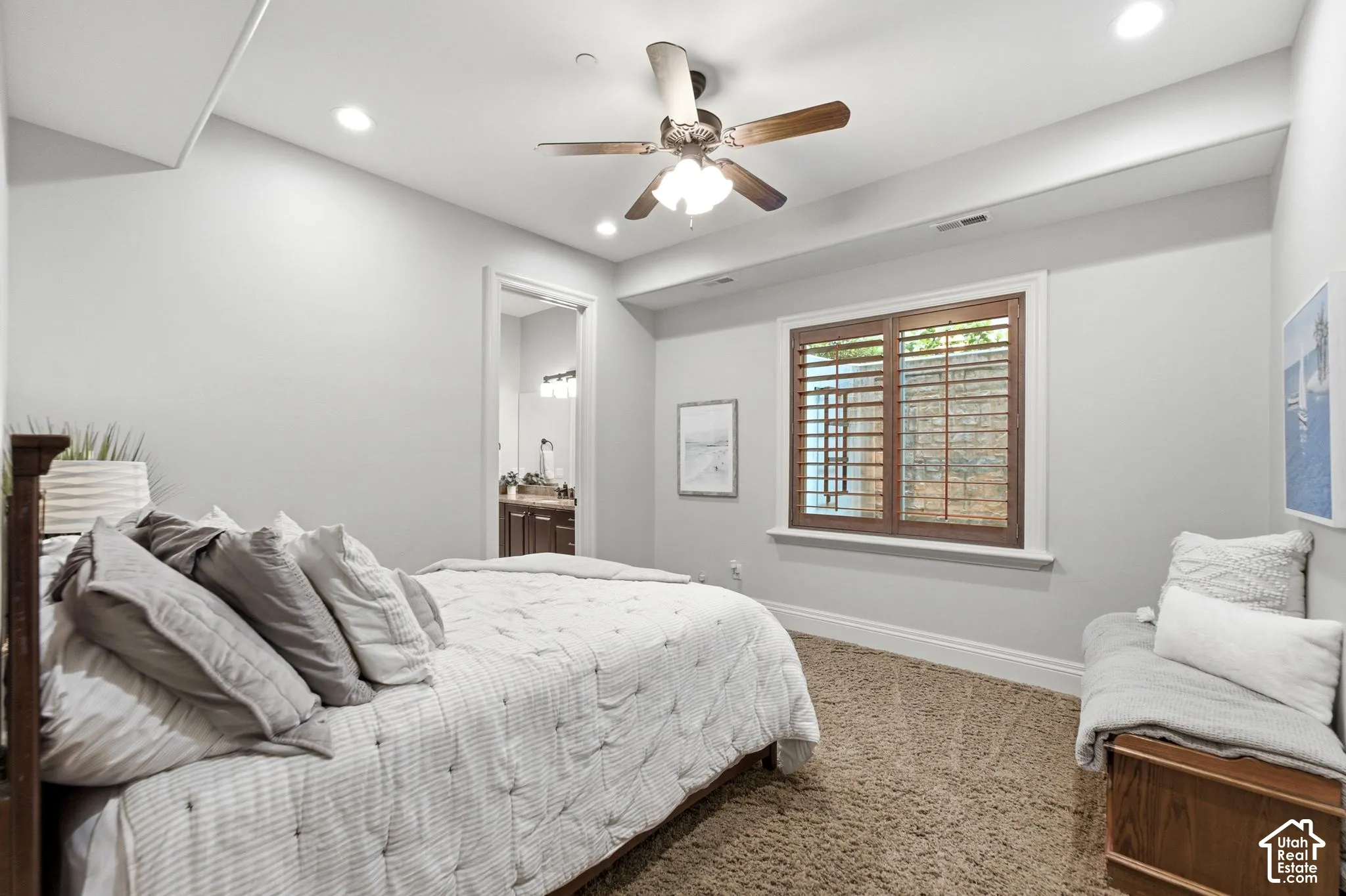 Recessed lighting illuminates the space, featuring a ceiling fan with light