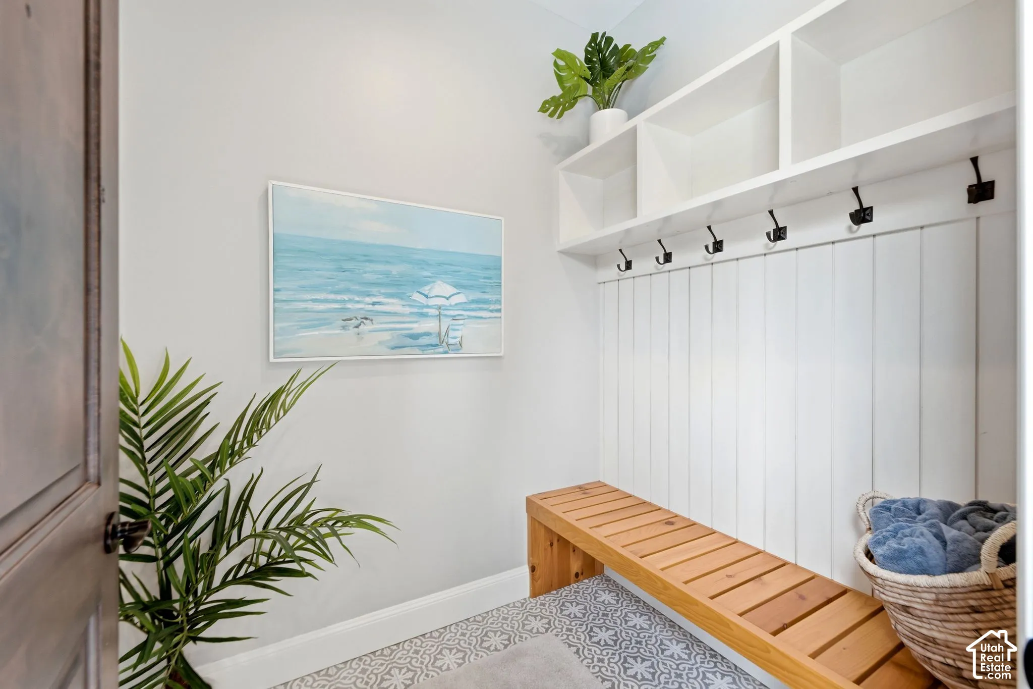 Casita Dressing AreaBuilt-in storage cubbies, white shiplap wall paneling, integrated coat hooks, natural wood-finish bench, and patterned floor tile