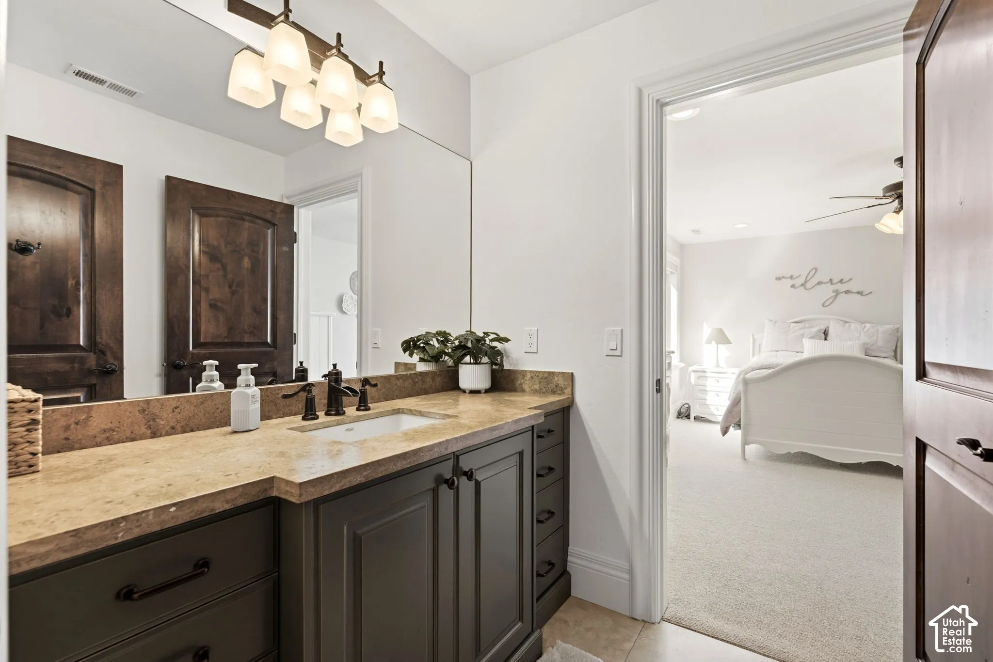 Vanity with a light-toned countertop, undermount sink, and dark cabinetry