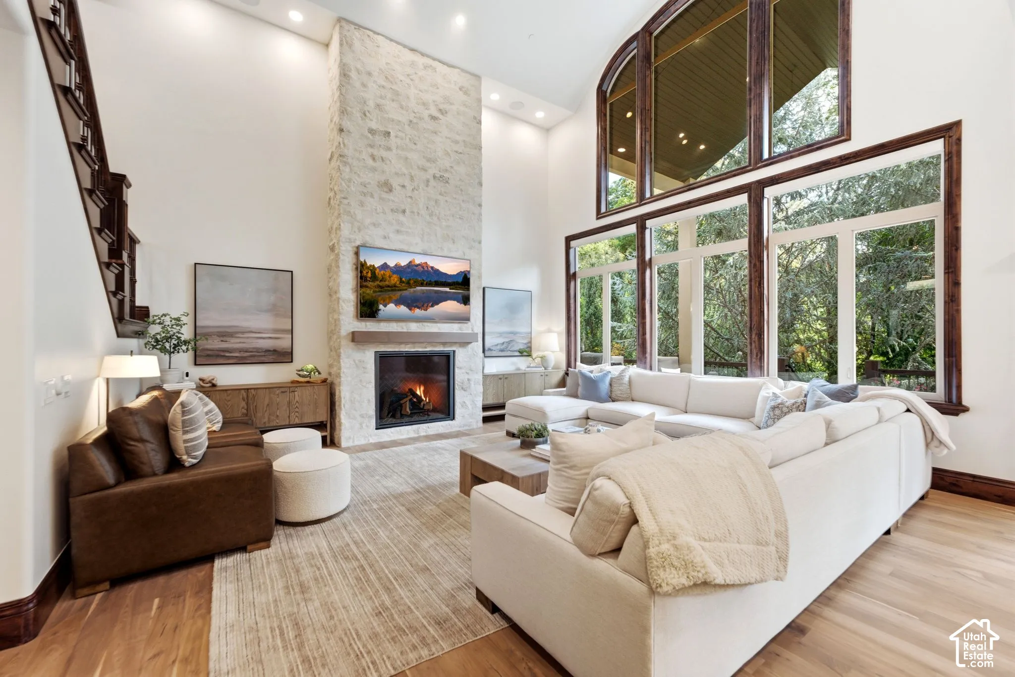 Two-story living area with a stone-clad fireplace and wood mantle