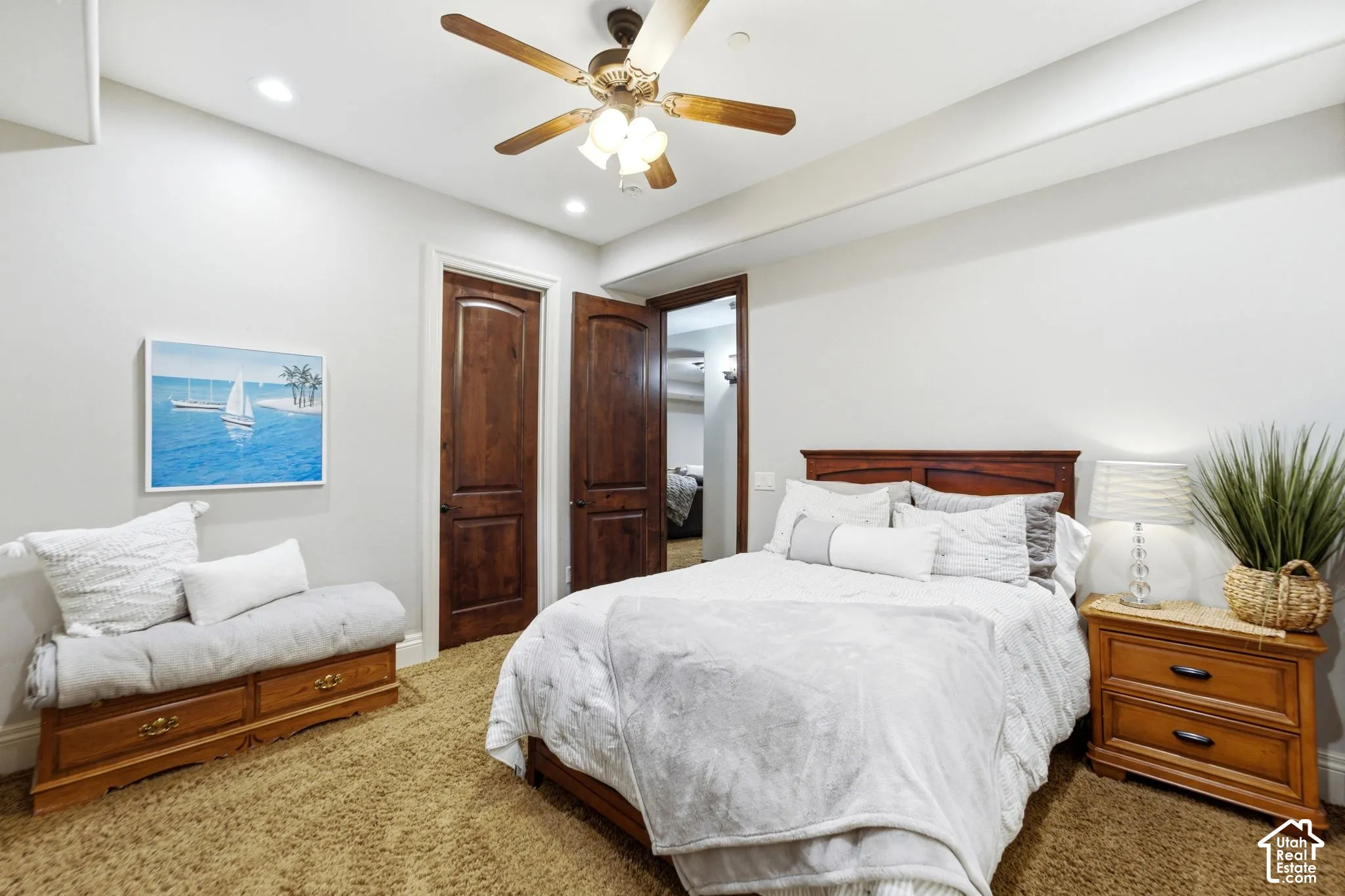 Recessed ceiling lighting, a wood-finish ceiling fan, and two paneled wood doors