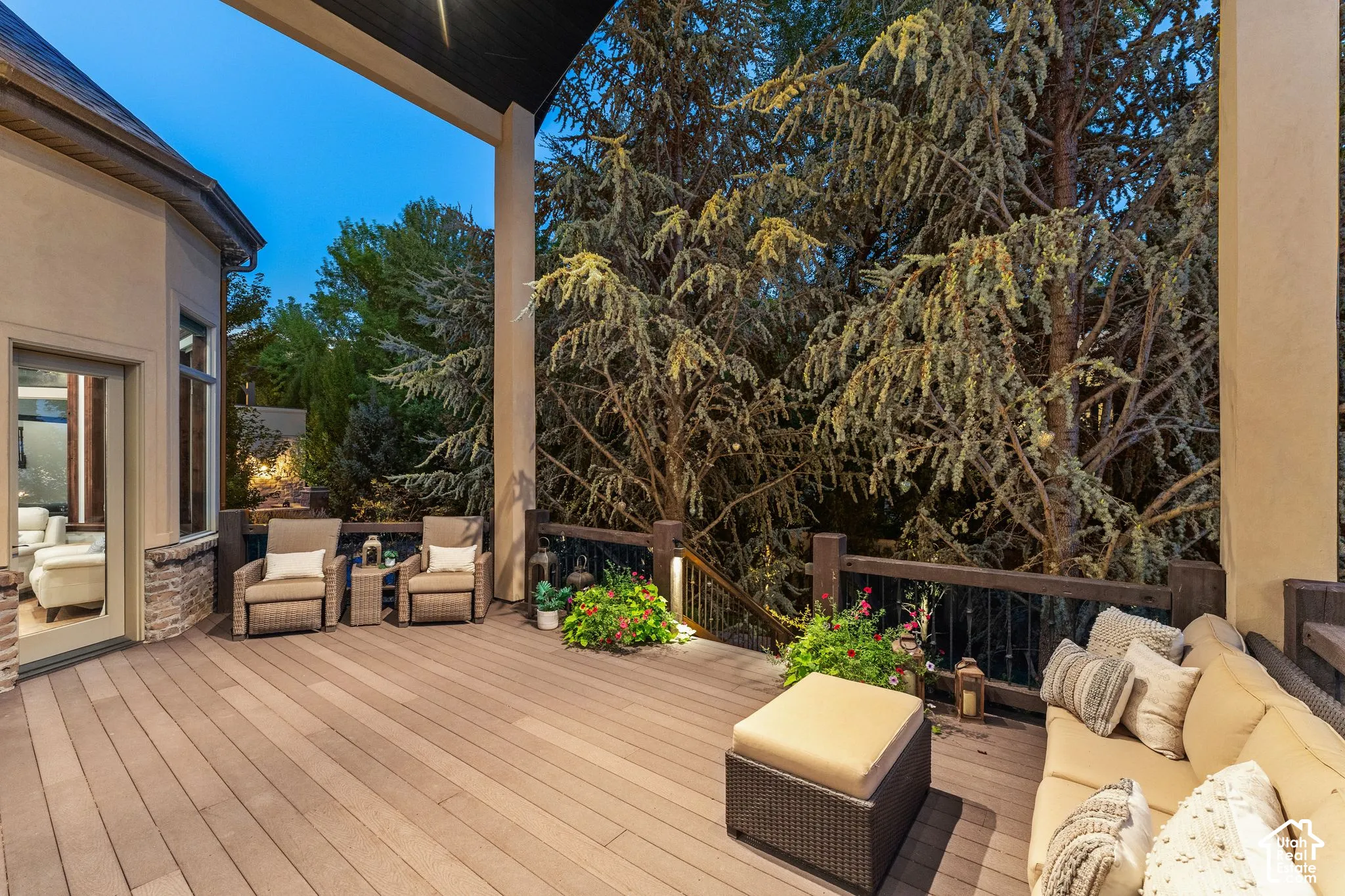 Spacious outdoor deck with wood-finish flooring, dark wood railings, and integrated lighting