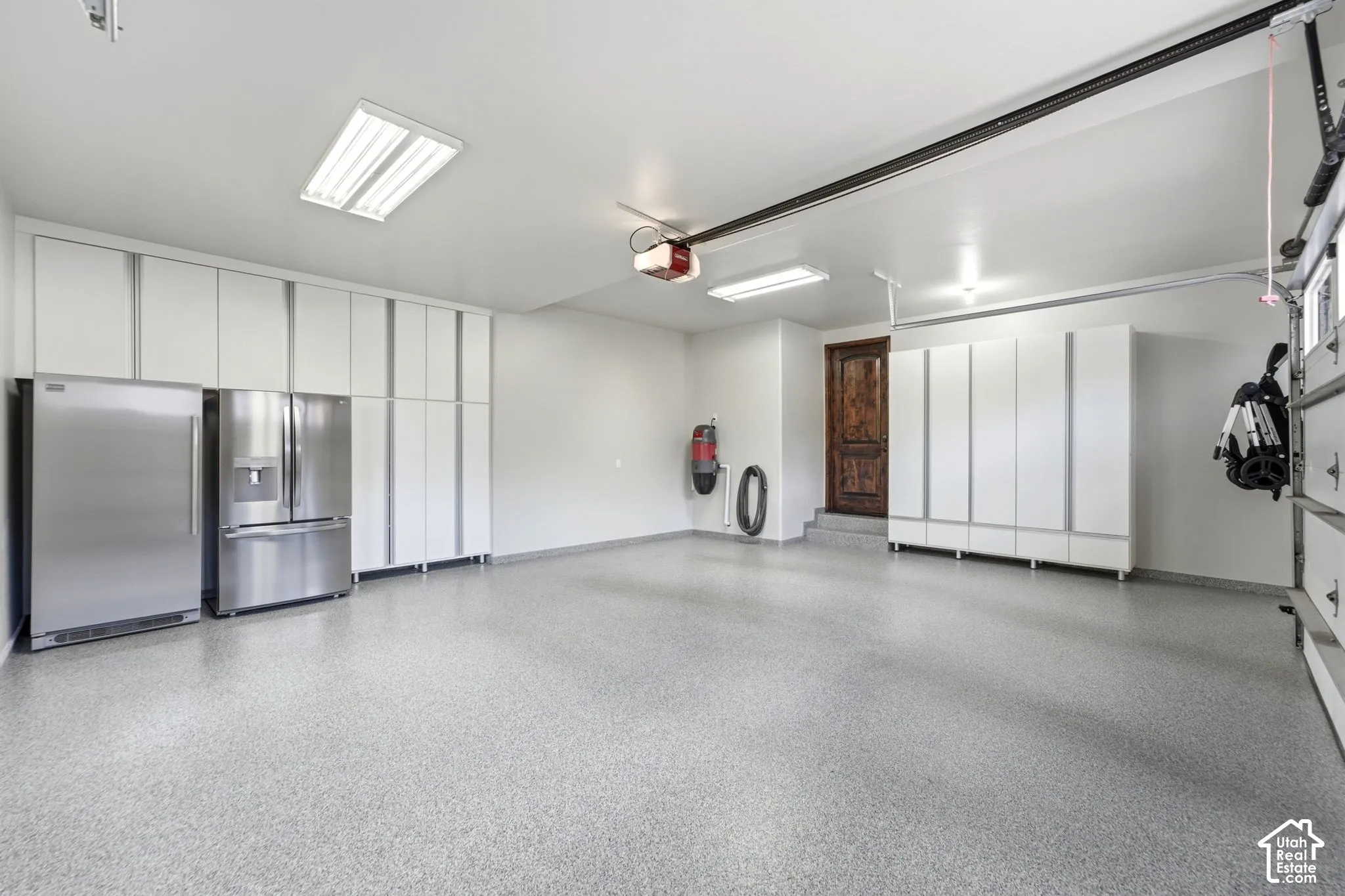 Epoxy-coated flooring, extensive built-in cabinetry, dual stainless steel refrigerators, and recessed lighting