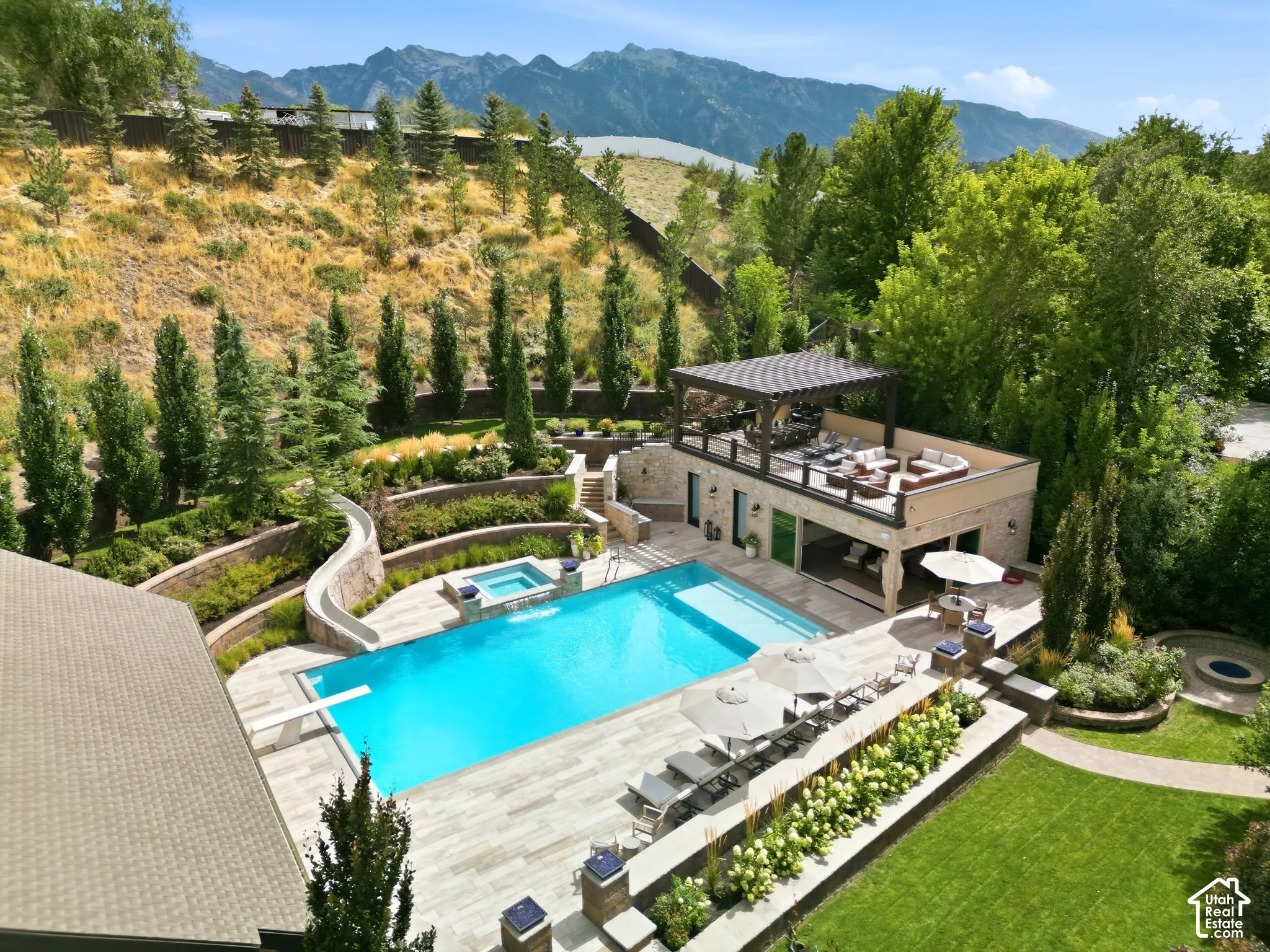 Expansive pool area featuring an in-ground pool, integrated hot tub, and diving board